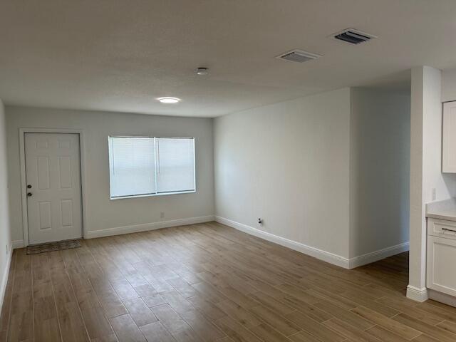 491 West Jordan Boulevard Pahokee, FL 33476 - Photo 4 of 10 a view of an empty room with wooden floor and a window