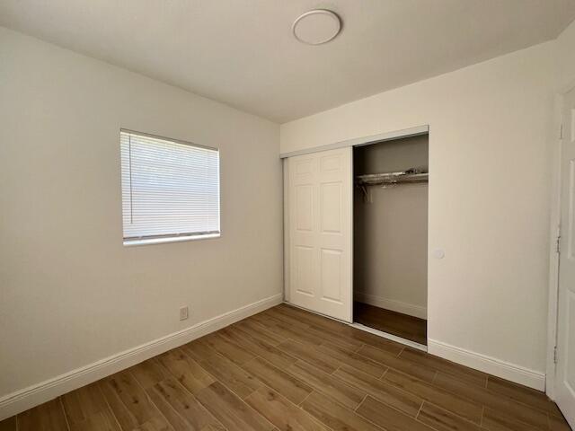 491 West Jordan Boulevard Pahokee, FL 33476 - Photo 9 of 10 a view of an empty room with wooden floor and a window