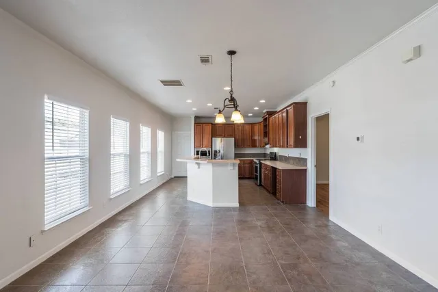 a view of a livingroom with wooden floor a ceiling fan and windows