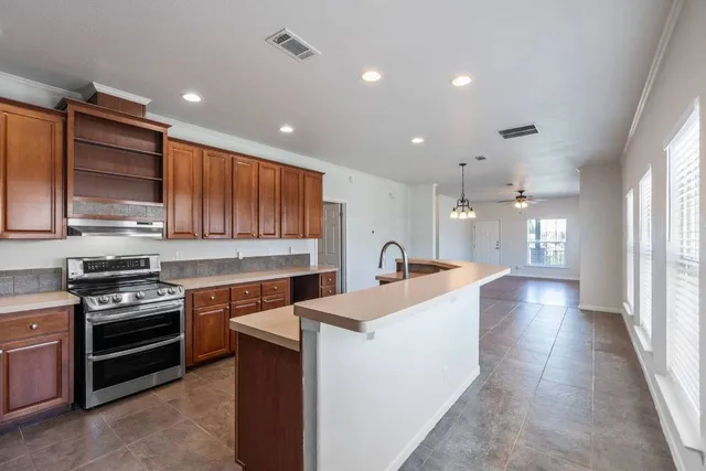 a large kitchen with a large window and stainless steel appliances