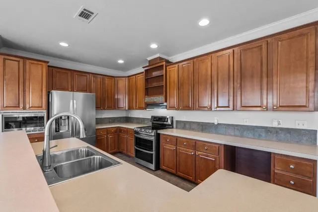 a kitchen that has a sink cabinets counter space and stainless steel appliances