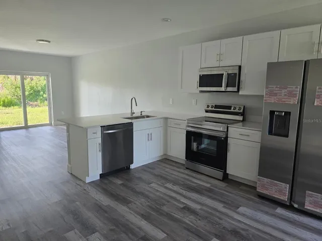 a kitchen with stainless steel appliances a stove a sink and a refrigerator