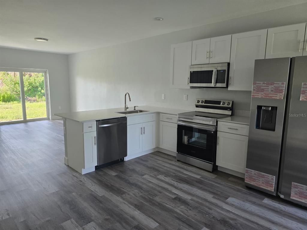12258 Henley Avenue, Unit B Port Charlotte, FL 33981 - Photo 15 of 39 a kitchen with stainless steel appliances a stove a sink and a refrigerator