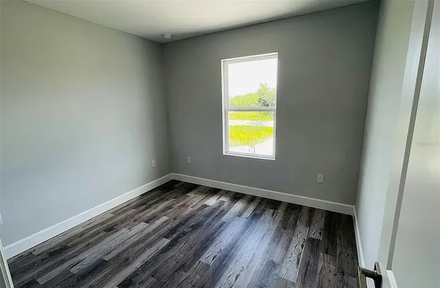 a view of a room with wooden floor and window