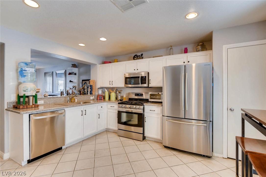 10451 Processor Court Las Vegas, NV 89129 - Photo 10 of 28 Culinary haven with stainless steel appliances and ample counter space for inspired cooking.