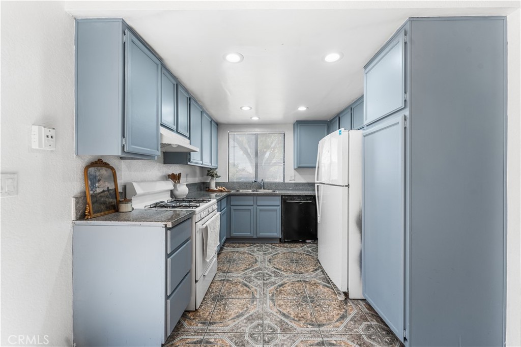 3542 East Ave R 10 Palmdale, CA 93550 - Photo 14 of 35 a kitchen with a sink a refrigerator and cabinets