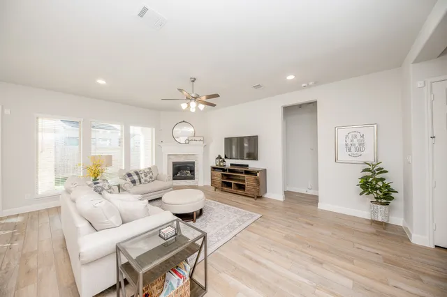 a living room with furniture a fireplace and a flat screen tv