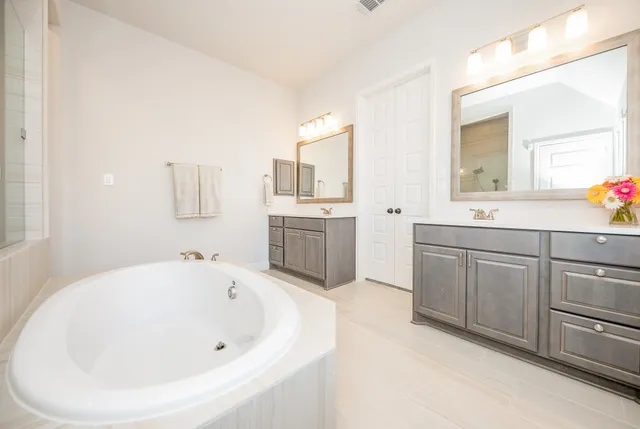 a bathroom with a bathtub sink and mirror