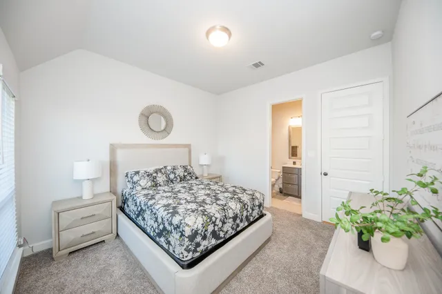 a bedroom with a bed and a potted plant