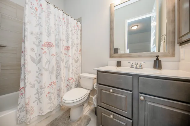 a bathroom with a granite countertop toilet sink and mirror