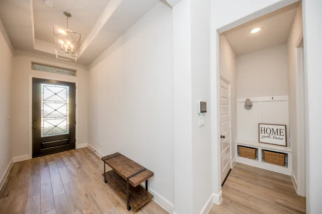 a view of a hallway with wooden floor and closet