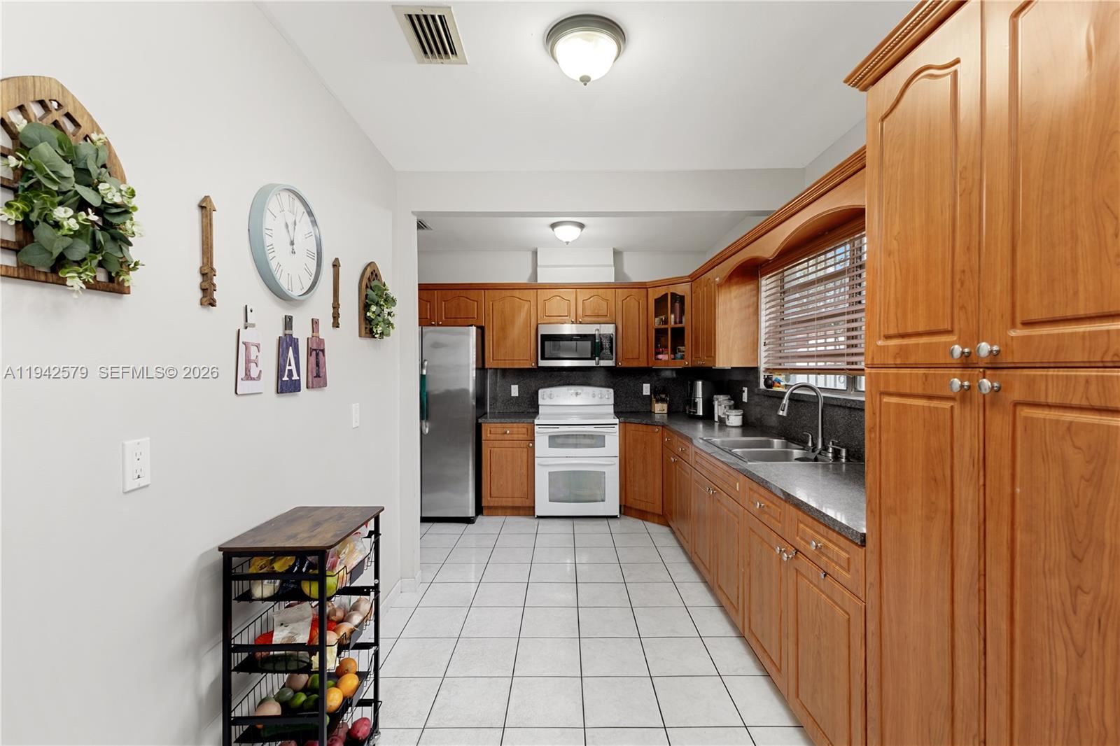 2818 Southwest 2nd Street Miami, FL 33135 - Photo 11 of 47 a kitchen with stainless steel appliances granite countertop a refrigerator and a stove top oven
