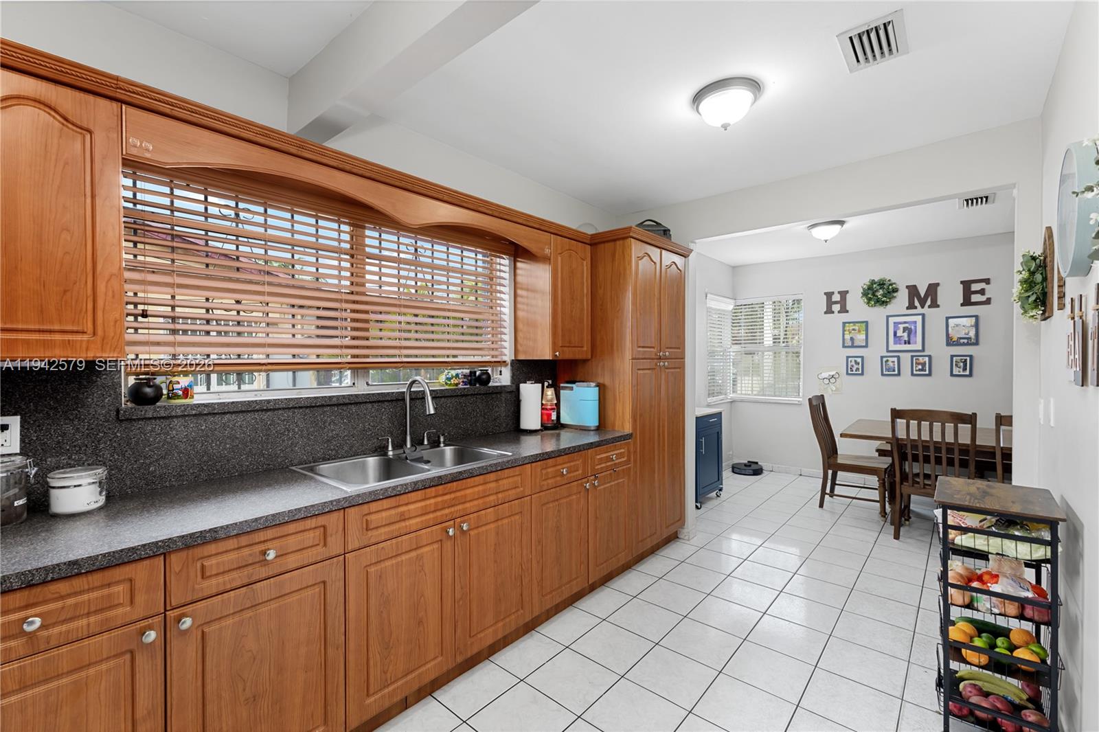 2818 Southwest 2nd Street Miami, FL 33135 - Photo 13 of 47 a kitchen with granite countertop a stove a sink and a wooden cabinets