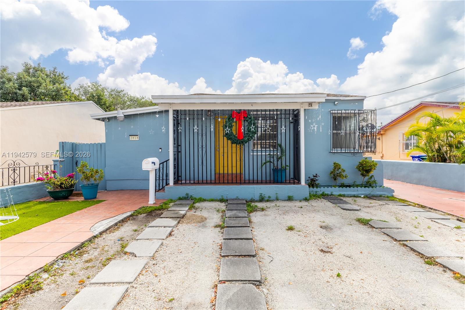 2818 Southwest 2nd Street Miami, FL 33135 - Photo 2 of 47 a front view of a house with a yard and potted plants