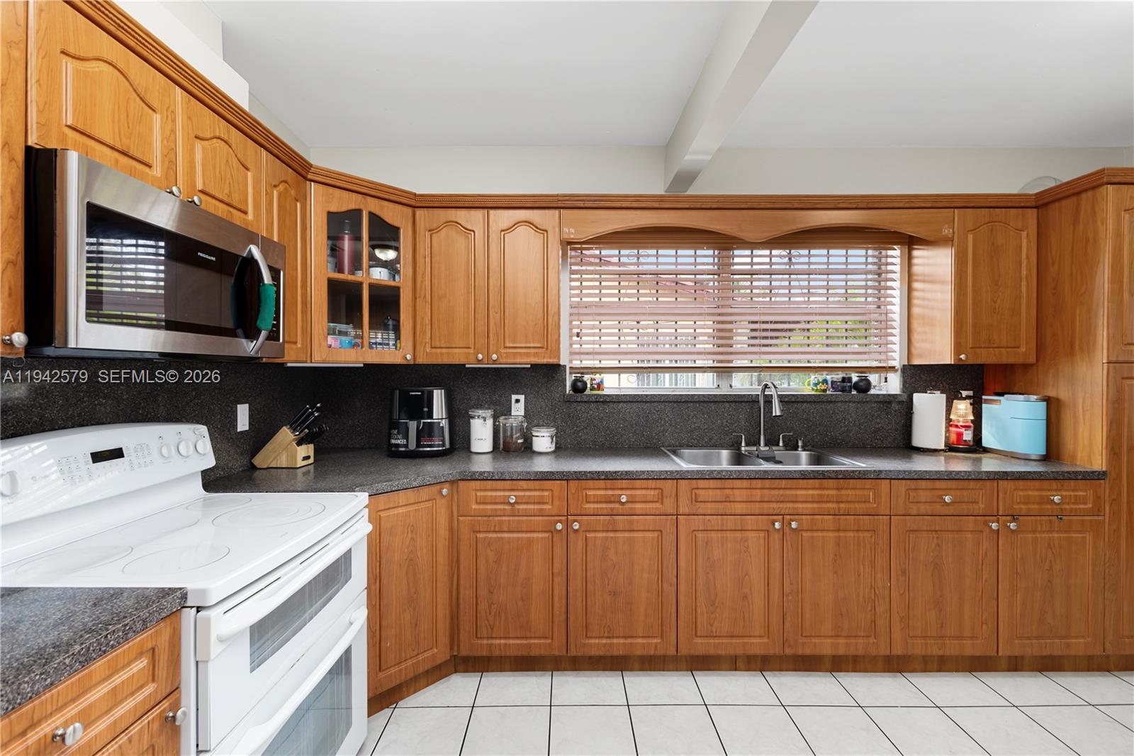 2818 Southwest 2nd Street Miami, FL 33135 - Photo 10 of 47 a kitchen with stainless steel appliances granite countertop a stove a sink a microwave and a refrigerator