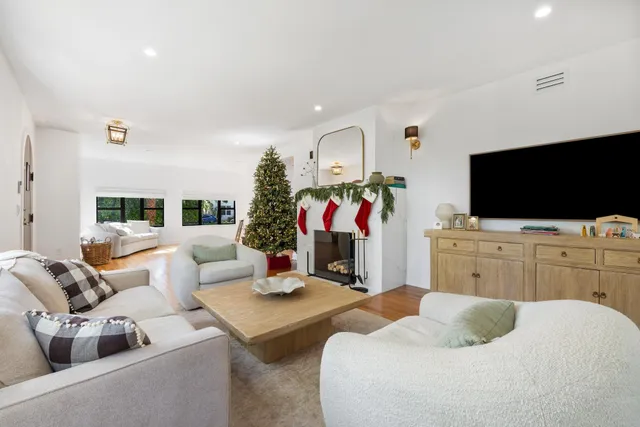 a view of a livingroom with wooden floor and a fireplace