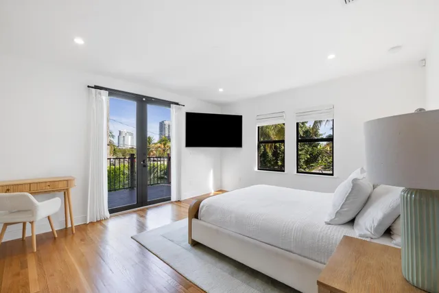 a view of an empty room with wooden floor and windows