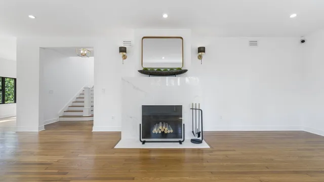 a view of a hallway with wooden floor and a fireplace