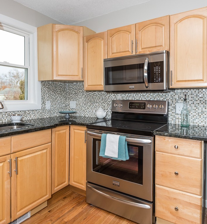 54 Ellendale Circle Springfield, MA 01128 - Photo 12 of 27 a kitchen with granite countertop white cabinets stainless steel appliances and a sink