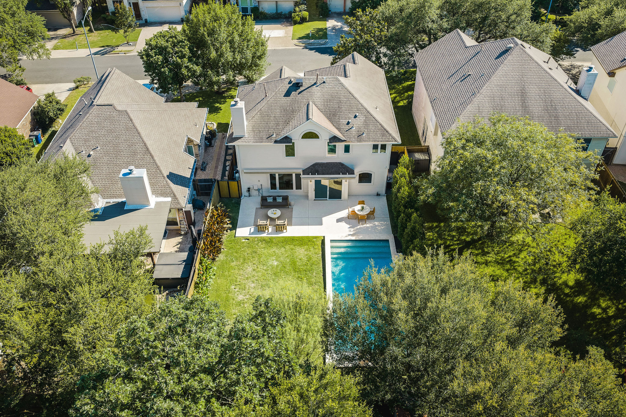 6500 Clay Allison Pass Austin, TX 78749 - Photo 5 of 39 Expansive backyard featuring a rectangular swimming pool, a substantial concrete patio, and a manicured lawn area