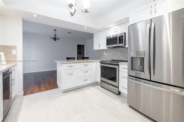 a kitchen with stainless steel appliances a stove a refrigerator and a microwave