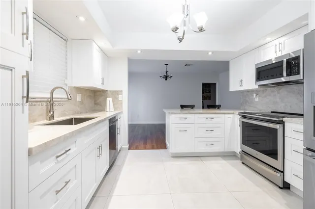 a kitchen with cabinets stainless steel appliances and a counter space