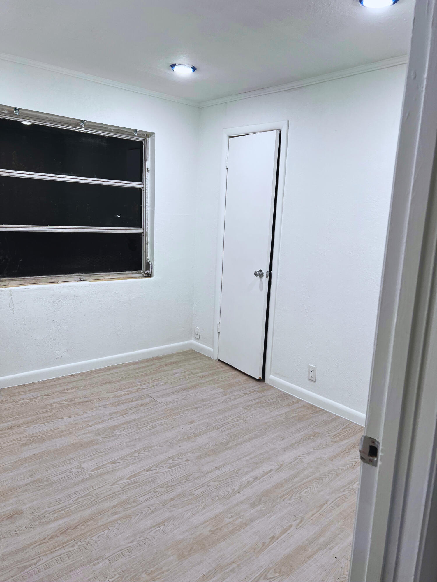 1340 West 33rd Street Riviera Beach, FL 33404 - Photo 5 of 18 a view of an empty room with wooden floor and window