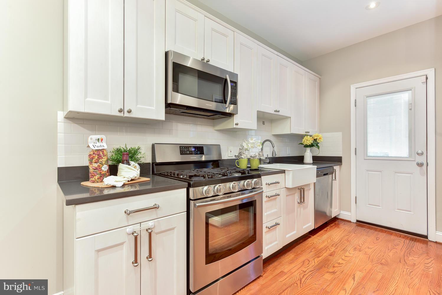 610 Columbia Road Northwest Washington, DC 20001 - Photo 8 of 29 a kitchen with stainless steel appliances granite countertop grey cabinets a stove a sink and dishwasher