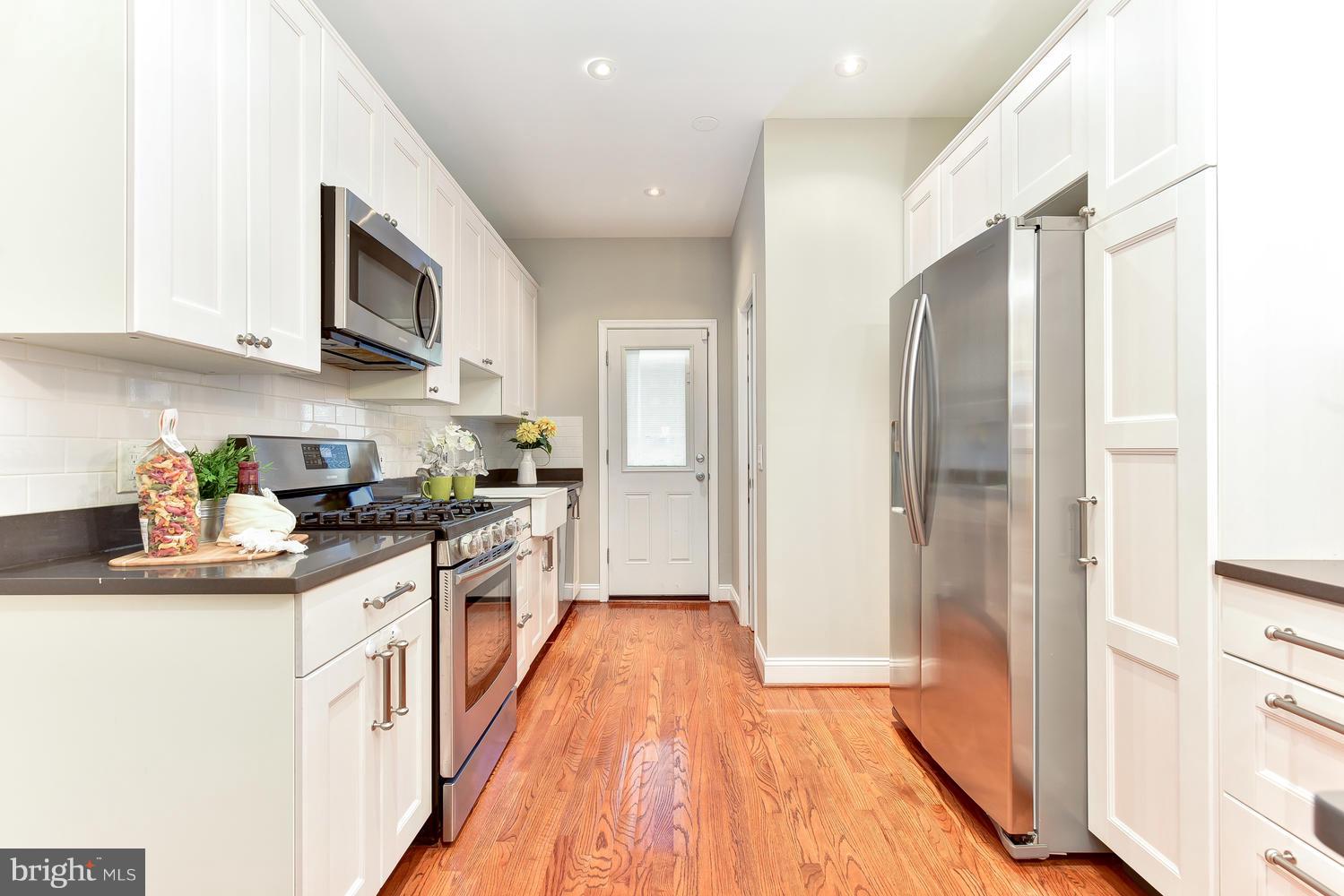 610 Columbia Road Northwest Washington, DC 20001 - Photo 9 of 29 a large kitchen with stainless steel appliances granite countertop a lot of cabinets and wooden floor