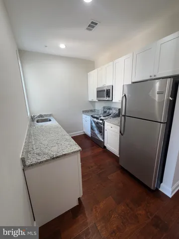 a kitchen with stainless steel appliances granite countertop a refrigerator sink and stove