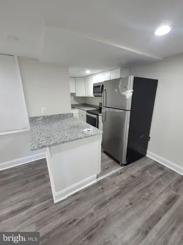 a kitchen with a refrigerator sink and wooden floor