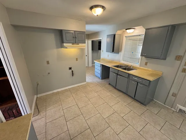 a large white kitchen with a sink a stove and a refrigerator
