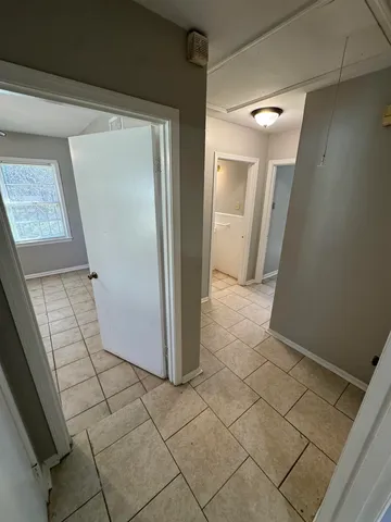 a view of a refrigerator in kitchen and an empty room