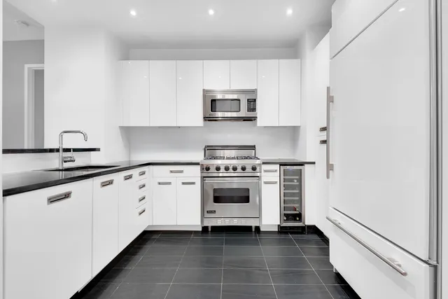 a kitchen with stainless steel appliances a stove a sink and a microwave