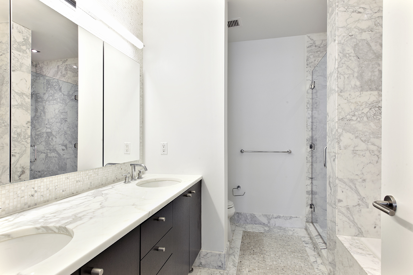 46-30 Center Boulevard, Unit 602 Queens, NY 11109 - Photo 6 of 18 a bathroom with a sink a toilet and shower