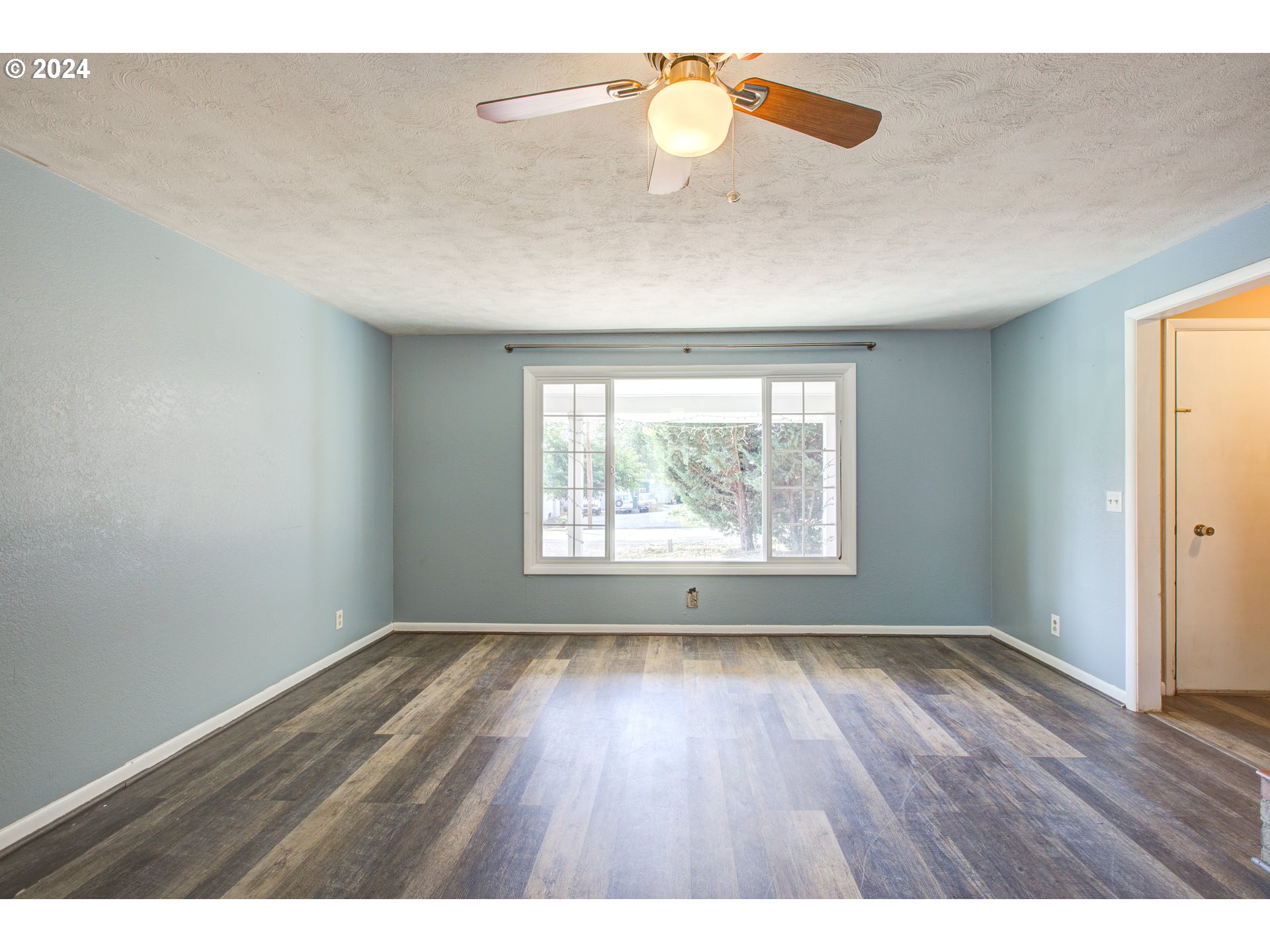 991 Mathis Hill Road Yoncalla, OR 97499 - Photo 6 of 42 an empty room with wooden floor and windows