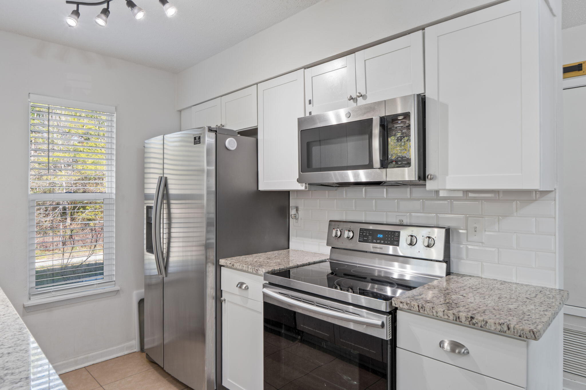 73 Kelly Way Valparaiso, FL 32580 - Photo 8 of 22 a kitchen with stainless steel appliances granite countertop a refrigerator microwave and stove top oven