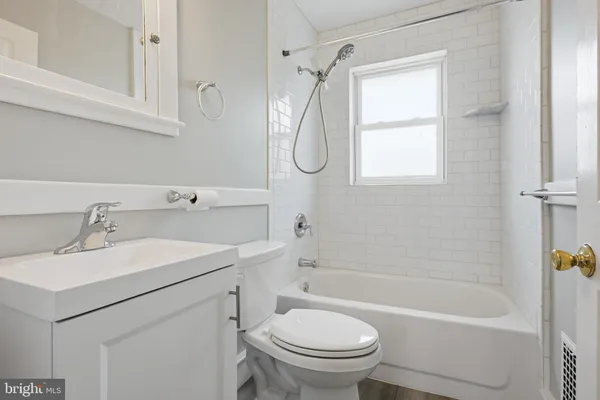 a bathroom with a sink toilet vanity and tub