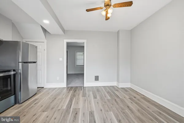 a view of a room with wooden floor and a ceiling fan