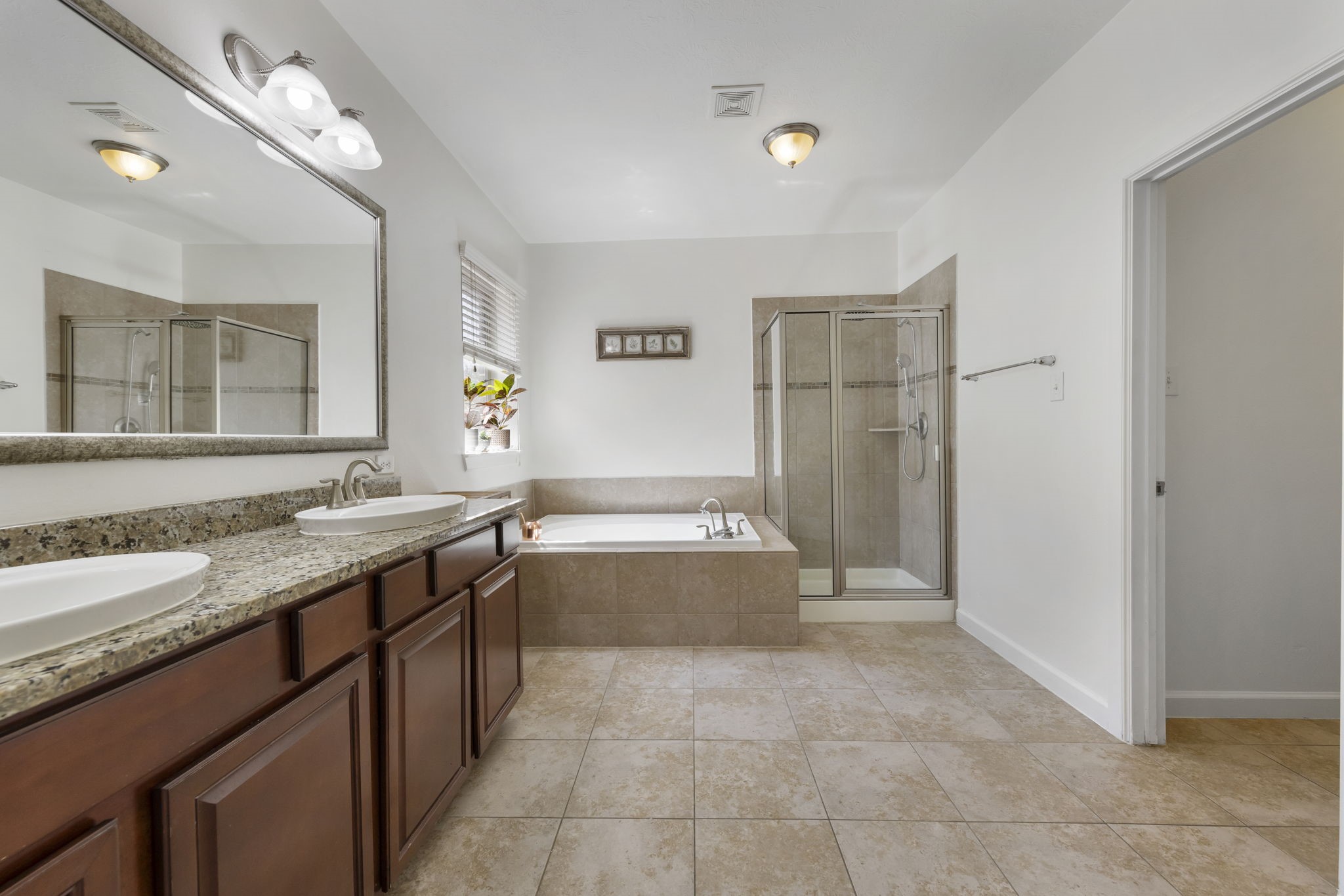 3318 Solvista High Court Spring, TX 77386 - Photo 17 of 33 Spa-inspired primary bath features dual granite vanities, a relaxing soaking tub, & separate glass-enclosed shower.