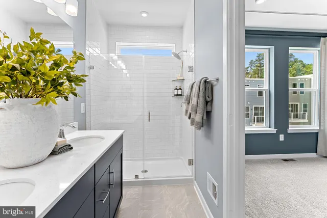 a bathroom with a granite countertop sink a toilet and shower