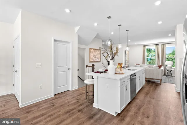 a kitchen that has a lot of white cabinets and wooden floor