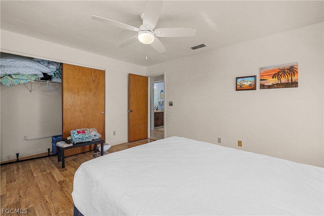 12170 Dolphin Road Bokeelia, FL 33922 - Photo 10 of 23 a bedroom with a bed and a chandelier