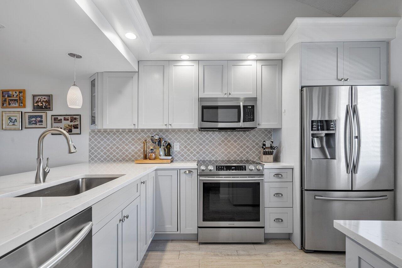 a kitchen with a sink stainless steel appliances and cabinets
