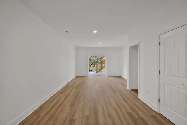 a bathroom with a toilet a sink and wooden floor