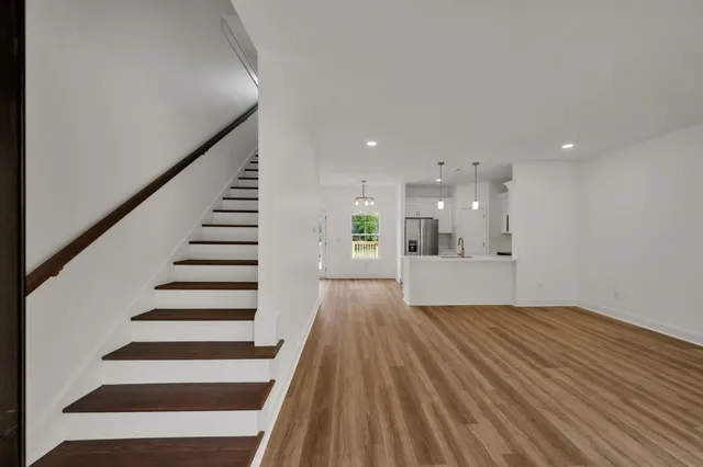 a view of a big room with wooden floors and stairs
