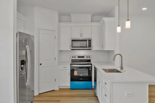 an empty room with wooden floor chandelier and windows