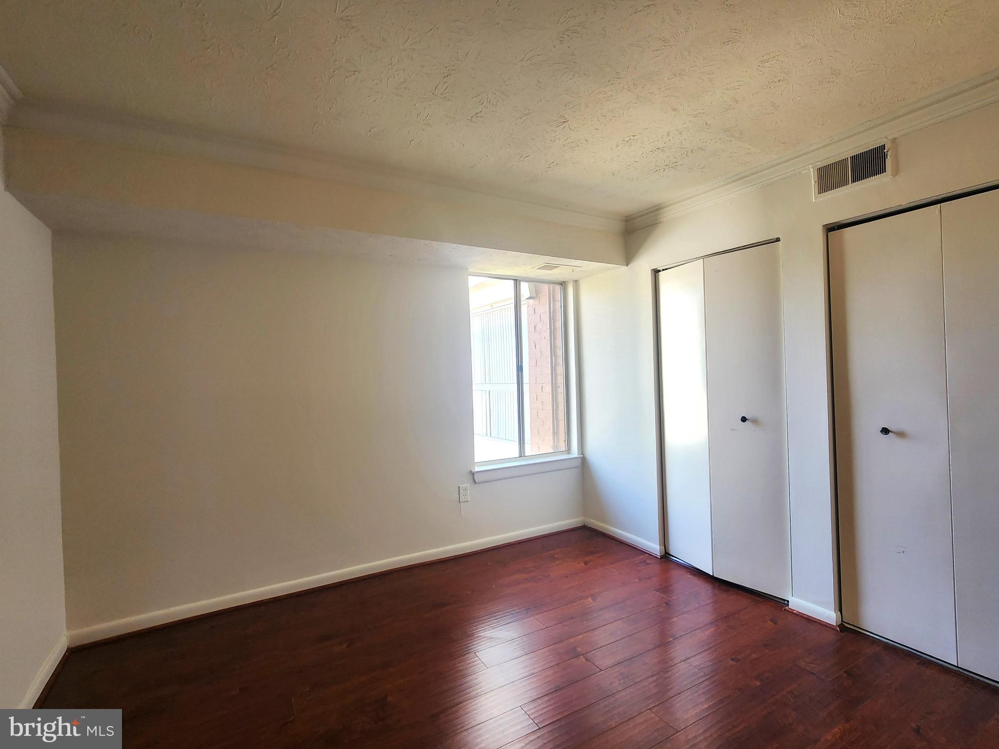 7919 Mandan Road, Unit 304 Greenbelt, MD 20770 - Photo 14 of 21 an empty room with wooden floor and window