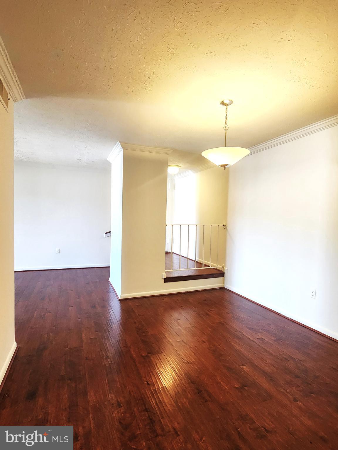 7919 Mandan Road, Unit 304 Greenbelt, MD 20770 - Photo 7 of 21 a view of an empty room with wooden floor and a window