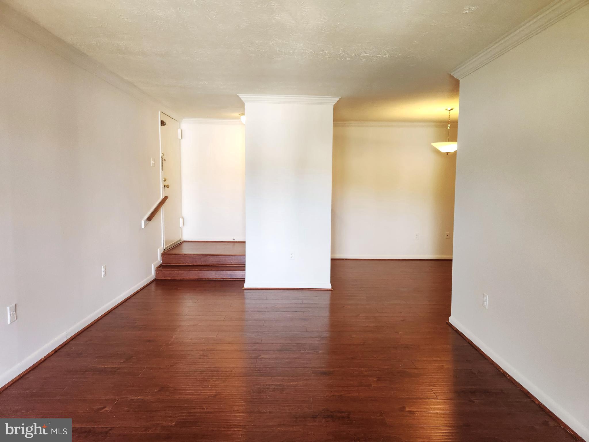 7919 Mandan Road, Unit 304 Greenbelt, MD 20770 - Photo 8 of 21 a view of an empty room with wooden floor and a window